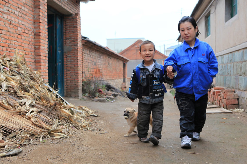 На фото: 23 ноября Сунь Сяоцзяо провожает сына в школу.